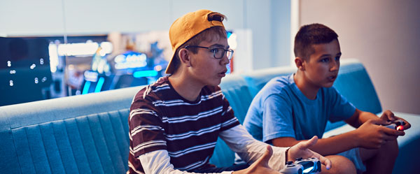 two people sitting on a couch playing video games